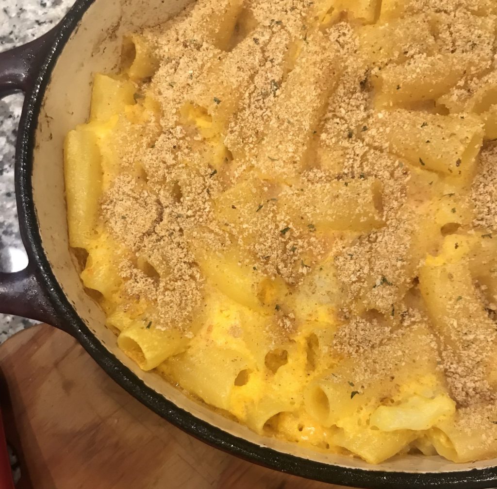 veggie loaded Mac and cheese in dutch oven on a wooden board